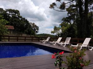 a swimming pool with lounge chairs next to a fence at Casa Europa in Monte Verde
