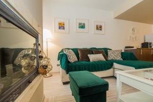 Una sala de estar con un sofá verde y una mesa. en Charming 2-Bedroom, Silver Mountain, A Building, en Poiana Brasov