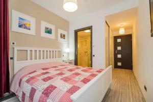 1 dormitorio con 1 cama con edredón rojo y blanco en Charming 2-Bedroom, Silver Mountain, A Building, en Poiana Brasov