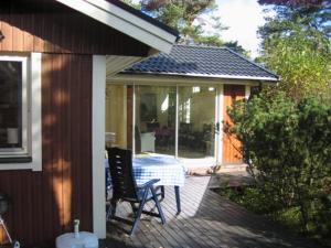 a patio with a table and chairs on a deck at Strandstugan in Degeberga