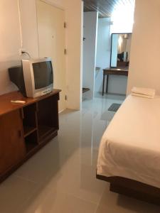 um quarto com uma cama e uma televisão numa secretária em Paradorn Inn em Chumphon