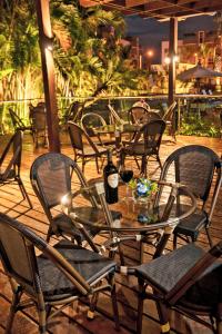 聖地亞哥洛斯卡巴的住宿－霍德帕花園酒店，夜晚在庭院里摆放着玻璃桌子和椅子