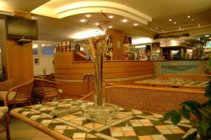 a glass vase sitting on a table in a restaurant at Hotel Kadett in Rimini +19 photos