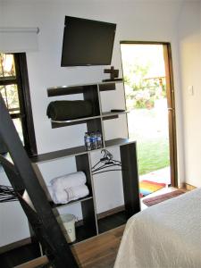 een kamer met een tv en een plank met handdoeken bij Los Vagones de William in Tibasosa