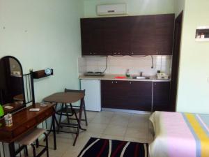 a small kitchen with a table and a bed at MUSSES in Stratoni