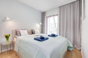 a bedroom with a large bed with blue towels on it at Apartamenty Black&White - Apartament Batory Five in Gdynia