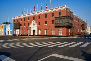 een groot rood gebouw met vlaggen erop bij Costa del Sol Trujillo Centro in Trujillo