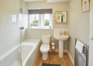 een badkamer met een toilet, een bad en een wastafel bij Host & Stay - Cosy Cottage in Emley