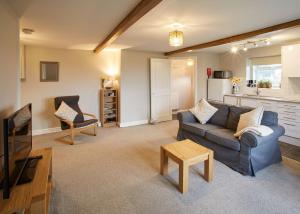 een woonkamer met een bank en een tafel bij Host & Stay - Cosy Cottage in Emley
