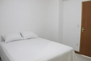 Una cama blanca con sábanas blancas y almohadas. en Residencial Copa 1, en Río de Janeiro