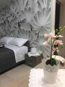 Un dormitorio con una cama y un jarrón con una flor en PEPPE'S HOME Luxury and relax apartament, en Gragnano