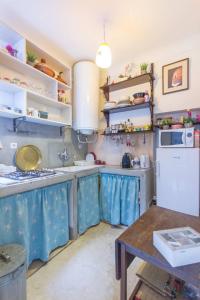 - une cuisine avec des rideaux bleus et un réfrigérateur blanc dans l'établissement Dar lalla, à Marrakech