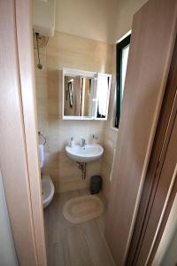 ein kleines Bad mit einem Waschbecken und einem WC in der Unterkunft Le Stanze di Casa Polinisso in Carovigno