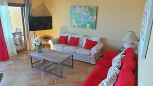 a living room with a red couch and a table at Villa Mia in Caleta De Fuste