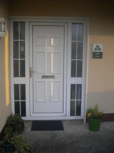 a white front door of a house with plants at Stonehaven B&B in Ennis