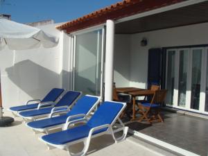 - un ensemble de chaises bleues assises sur une terrasse dans l'établissement Villa Caballero, à Alfundão