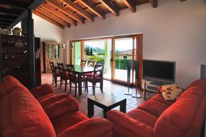 a living room with a red couch and a television at Spacious Villa in Parecag with a Swimming Pool in Sečovlje