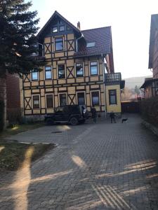 a man walking a dog in front of a house at Harzer Ferienlodge in Wernigerode