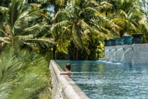 a woman is sitting in a swimming pool at Four Seasons Resort Langkawi in Tanjung Rhu