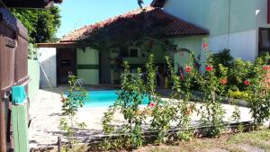 uma casa com piscina e algumas flores em Casa completa em Peró! em Cabo Frio