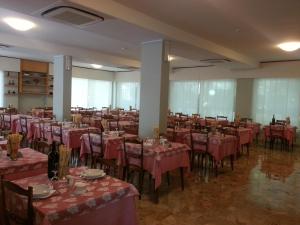 um salão de banquetes com mesas e cadeiras com toalha de mesa vermelha em Hotel Irene em Riccione