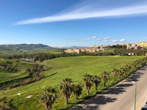 a road with palm trees on the side of a hill at Tenute D'Angelo - Holidays, Relax & Wellness - Casa vacanze ad Agrigento in Agrigento