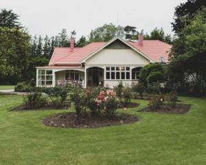 ein Haus mit einem Blumengarten davor in der Unterkunft Hemsworth Estate in Elgin