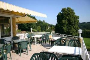 een groep tafels en stoelen op een patio bij Hotel Café Talblick in Vielbrunn