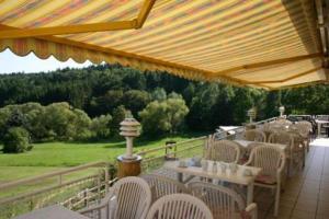 - une rangée de tables et de chaises sur la terrasse dans l'établissement Hotel Café Talblick, à Vielbrunn