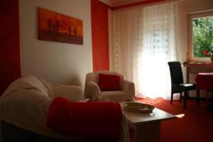 a living room with a couch and chairs and a window at Hotel Café Talblick in Vielbrunn