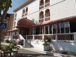 a white building with windows and plants in front of it at Hotel Victory in Cesenatico