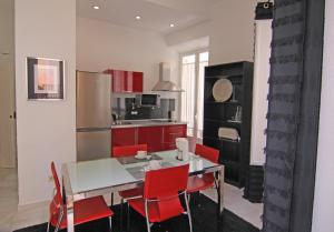 une cuisine avec une table blanche et des chaises rouges dans l'établissement Living Sevilla Apartments Catedral, à Séville
