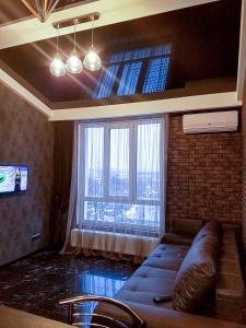 a living room with a couch and a large window at В стиле LOFT 2ухэтажная квартира. in Kharkiv