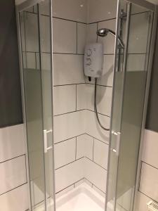 a shower with a glass door in a bathroom at The Pheasant Inn in Dunstable