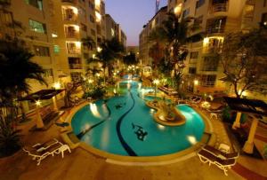 a large swimming pool in a city at night at Star of Hin Nam Condominium in Hua Hin