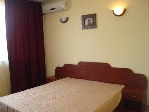a bedroom with a bed and a dresser and a window at Hotel Terra in Eforie Nord
