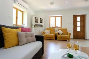 a living room with a couch and two glasses of wine at House Marijan in Šestanovac