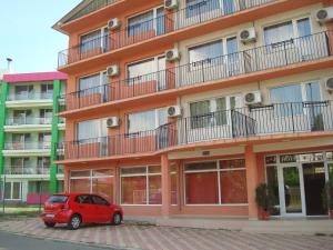 a red car parked in front of a building at Hotel Terra in Eforie Nord