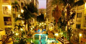 a large swimming pool in a city at night at Star of Hin Nam Condominium in Hua Hin