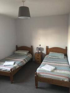 two twin beds in a room with a lamp at The Pheasant Inn in Dunstable