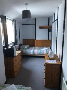een slaapkamer met 2 bedden, een bureau en een televisie bij The Pheasant Inn in Dunstable