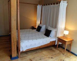 ein Schlafzimmer mit Himmelbett und Holzboden in der Unterkunft Hotel am Hoken in Quedlinburg