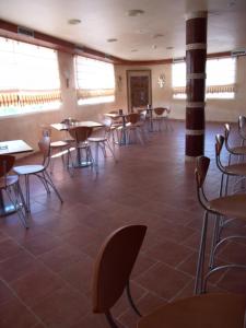 a dining room with tables and chairs and windows at Valle del Nilo in Ventas de Poyo