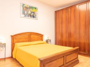 una camera con letto giallo e armadio in legno di Résidence Villa Smeralda a Telti