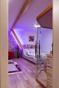 a attic bedroom with a bed and a bath tub at Romantický wellness suite hotel Heinz in Dobříš