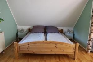 ein Schlafzimmer mit einem Holzbett mit lila Kissen in der Unterkunft "Ferienwohnung Am Tharandter Wald" in Grund