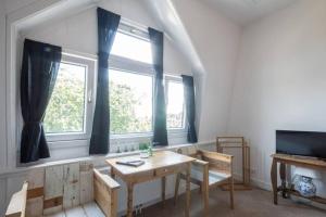 ein Esszimmer mit einem Tisch und einem Fenster in der Unterkunft B&B Valkenbos in Den Haag
