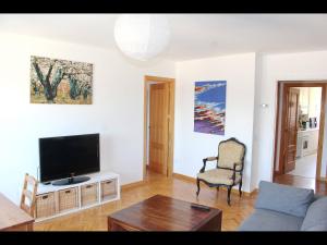 a living room with a couch and a tv at Luminoso Piso en Navacerrada Wifi in Navacerrada