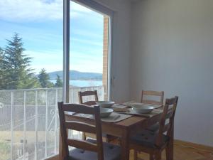 a dining room table with chairs and a large window at Luminoso Piso en Navacerrada Wifi in Navacerrada