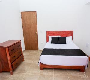 a bedroom with a bed and a wooden dresser at Hotel Madre Laura Jericó in Jericó